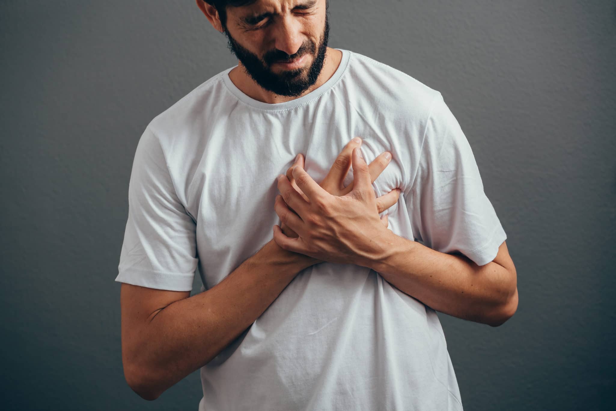 People, healthcare and problem concept - close up of man suffering from heart ache over gray background