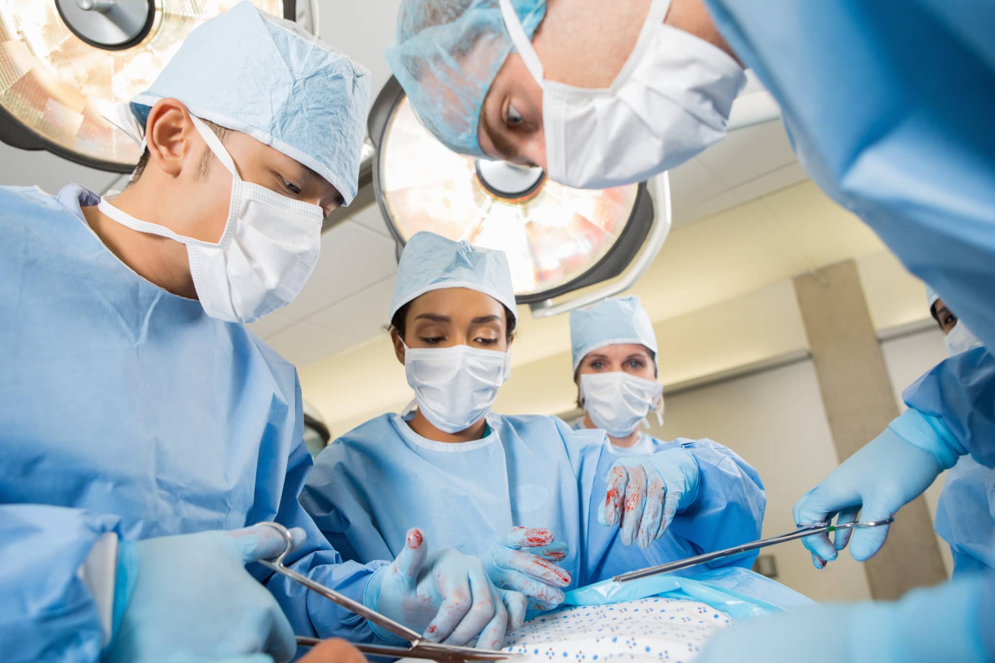 Surgeons performing heart operation on patient in operating room